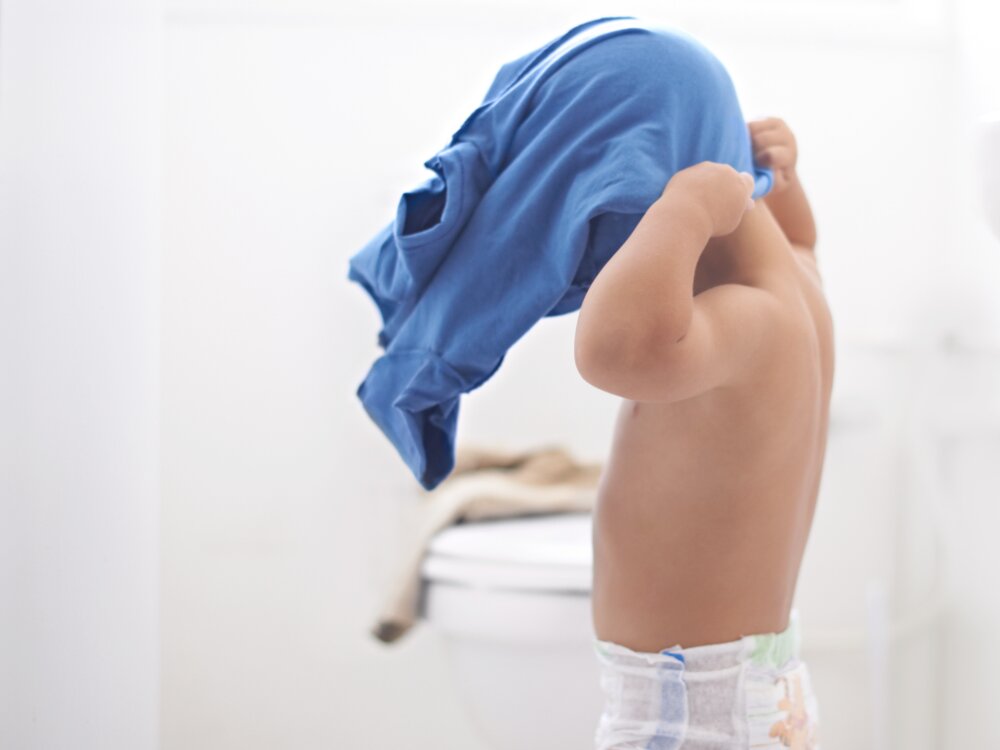 Child putting t-shirt on