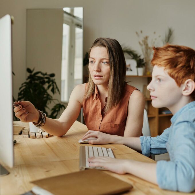 Mother and son sit at a computer